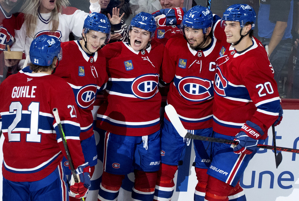 Montreal Canadiens' Cole Caufield (13) celebrates his goal over the Seattle Kraken with teammates from left to right Kaiden Guhle (21), Lane Hutson (48), Nick Suzuki (14) and Juraj Slafkovsky (20) during second period NHL hockey action in Montreal on Tuesday, Oct. 14, 2025. (Christinne Muschi/The Canadian Press via AP)
