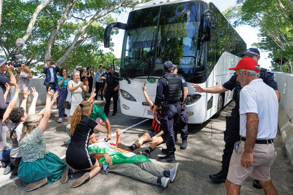 Protesters block the progress of a bus believed to be carrying the Iranian women's soccer team as it attempts to leave a hotel on the Gold Coast, Australia, Tuesday, March 10, 2026. (Russell Freeman/AAPImage via AP)