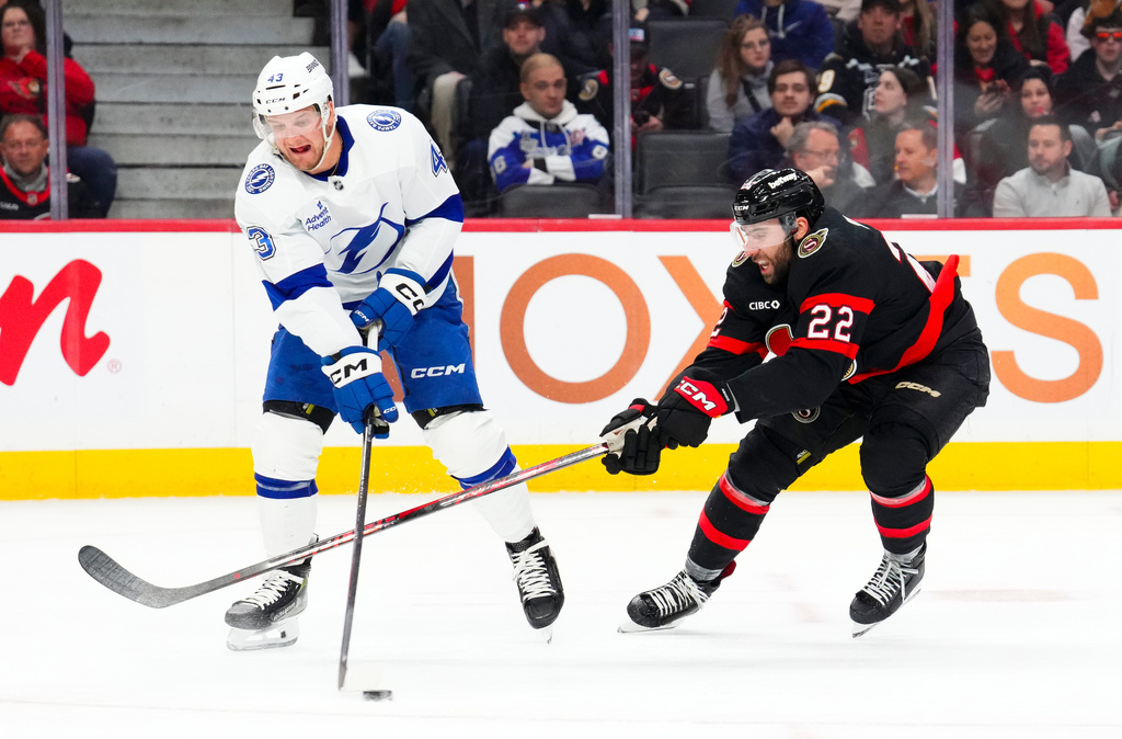 Ottawa Senators' Michael Amadio (22) tries to stop Tampa Bay Lightning's Darren Raddysh (43) from clearing the puck during the second period of an NHL hockey game in Ottawa on Tuesday, April 7, 2026. (Sean Kilpatrick/The Canadian Press via AP)