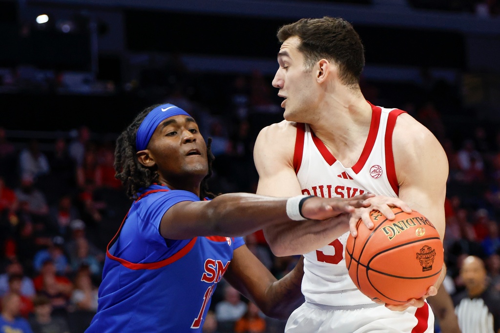 Louisville forward Vangelis Zougris, right, battles SMU center Jaden Toombs for the ball during the first half of an NCAA college basketball game in the second round of the Atlantic Coast Conference tournament in Charlotte, N.C., Wednesday, March 11, 2026. (AP Photo/Nell Redmond)