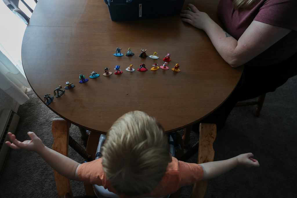 Meygan Maloney and her son, Callum Wilson, 3, play with figurines Friday, Aug. 28, 2026, at their home in Hartford City, Ind. (AP Photo/Cara Penquite)