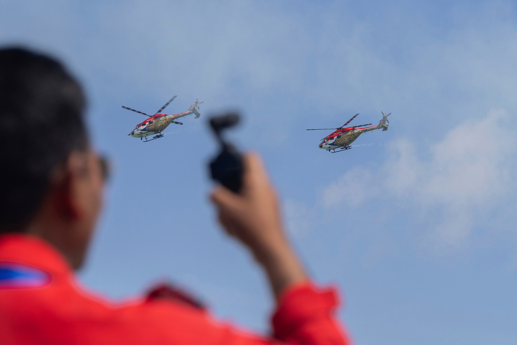 A ground crew watches Sarang aerobatics display team from India at the Singapore Air Show on Thursday, Feb. 5, 2026. (AP Photo/Anton L. Delgado)