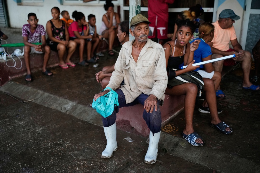 People wait to charge electrical appliances in El Cobre, Cuba, Wednesday, Oct. 29, 2025, in the aftermath of Hurricane Melissa. (AP Photo/Ramon Espinosa)
