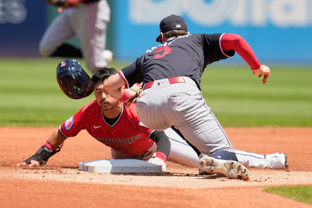 Cleveland Guardians' Steven Kwan, left, steals second base under the tag of Minnesota Twins shortstop Ryan Kreidler, right, in the first inning of a baseball game in Cleveland, Thursday, July 23, 2026. (AP Photo/Sue Ogrocki)
