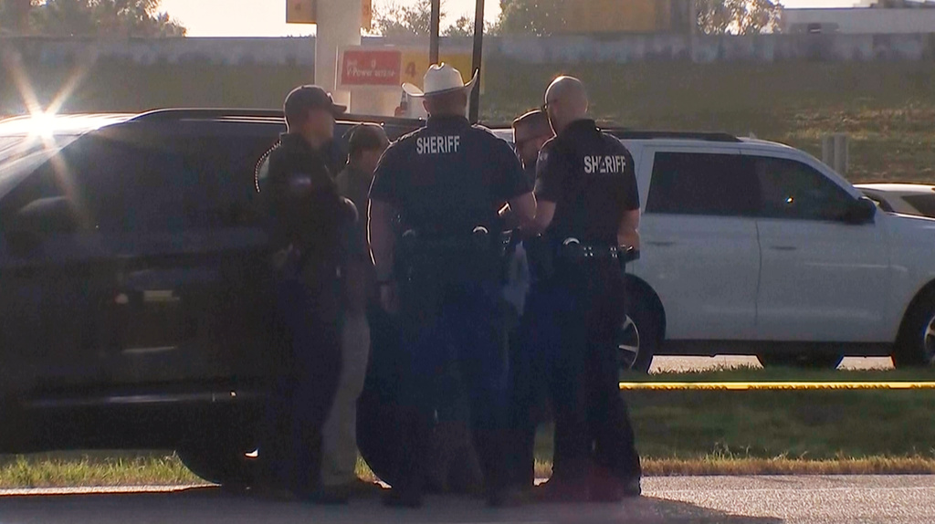 Law enforcement officials investigate a vehicle near the scene of a deadly shooting shooting early Saturday, Oct. 4, 2025 in the Houston suburb of Angleton, Texas. (KTRK via AP)