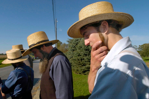 FILE - In this Oct. 2, 2006 photo, Amish men gather across the street from the one-room schoolhouse in Nickel Mines, Pa., after a fatal shooting at the school. (John Makely/The Baltimore Sun via AP, file) FILE - In this Oct. 2, 2006 photo, Amish men gather across the street from the one-room schoolhouse in Nickel Mines, Pa., after a fatal shooting at the school. (John Makely/The Baltimore Sun via AP, file)