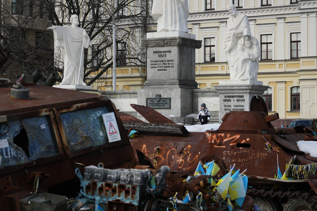 A child plays next to an open air exhibition of destroyed Russian military equipment in Kyiv, Ukraine, Saturday, Feb. 28, 2026. (AP Photo/Sergei Grits)