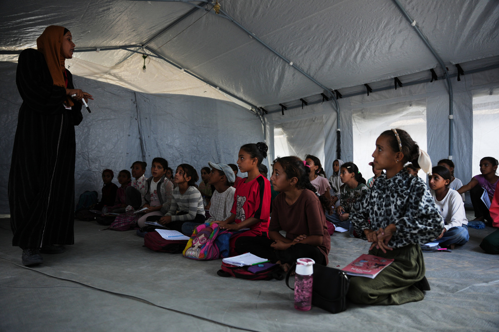 Palestinian students attend class inside a tent set up on the beach in Khan Younis, Gaza Strip, Wednesday, Nov. 12, 2025. (AP Photo/Abdel Kareem Hana)
