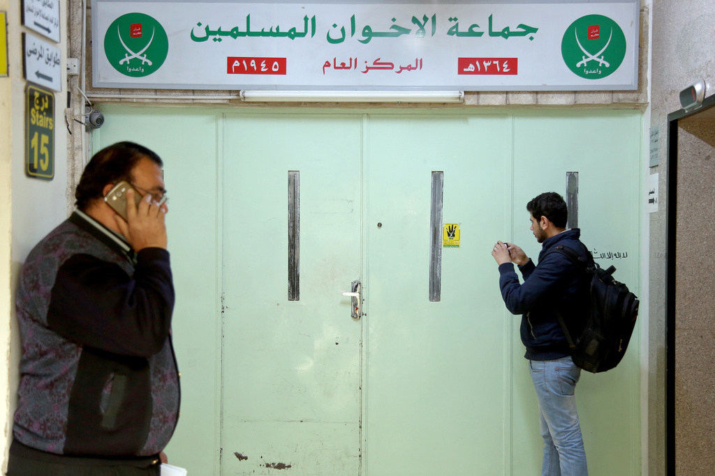FILE - A man photographs the main entrance of the original Muslim Brotherhood office, that is sealed with official wax after it was raided and shut down by police, in Amman, Jordan, Wednesday, April 13, 2016. (AP Photo/Raad Adayleh, file)