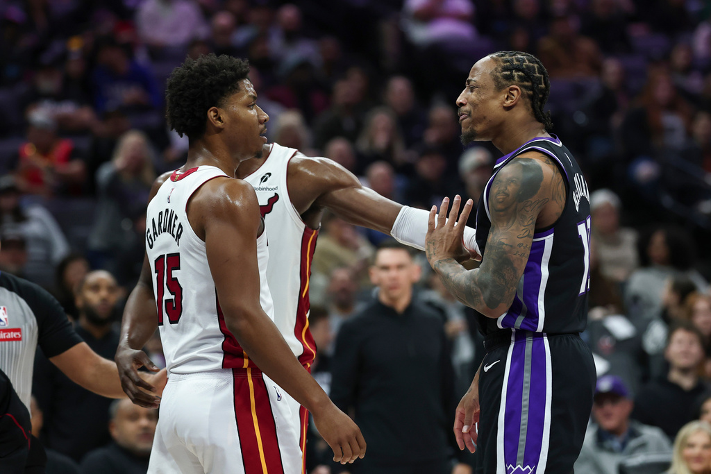 Miami Heat center Bam Adebayo, background, holds back Sacramento Kings guard DeMar DeRozan, right, and Miami Heat forward Myron Gardner (15) as they confront each other after a foul during the first half of an NBA basketball game Tuesday, Jan. 20, 2026, in Sacramento, Calif. (AP Photo/Sara Nevis)