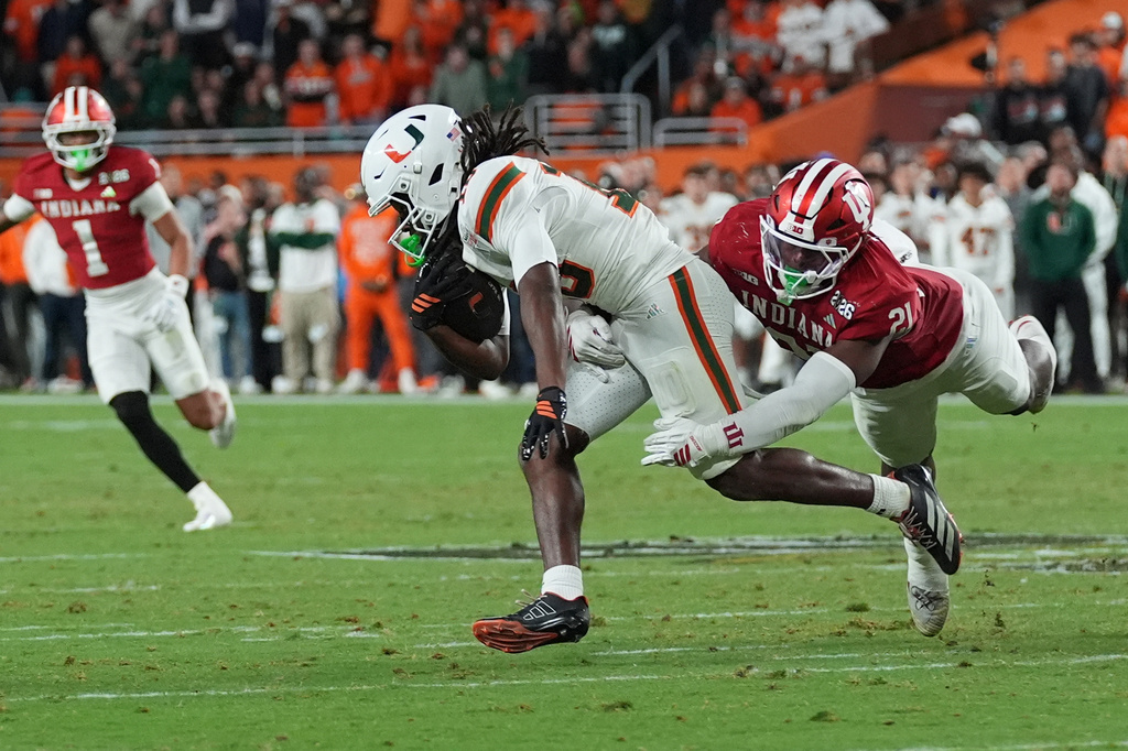 FILE - Indiana linebacker Rolijah Hardy (21) grabs Miami wide receiver Malachi Toney (10) during the College Football Playoff national championship game, Tuesday, Jan. 20, 2026, in Miami Gardens, Fla. (AP Photo/Marta Lavandier, file)