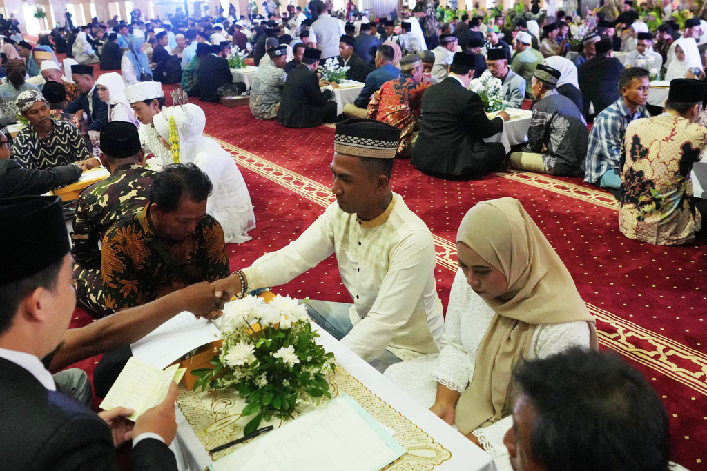 A couple gets married during a mass wedding ceremony at Istiqlal Mosque in Jakarta, Indonesia, Wednesday, Dec. 3, 2025. (AP Photo/Tatan Syuflana)