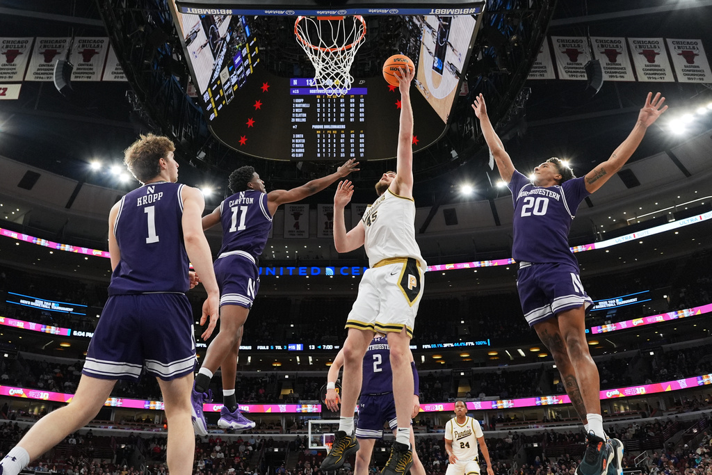 Purdue center Oscar Cluff (45) shoots as Northwestern guard Jordan Clayton (11) and guard Justin Mullins (20) defend during the first half of an NCAA college basketball game in the third round of the Big 10 Conference tournament Thursday, March 12, 2026, in Chicago. (AP Photo/Nam Y. Huh)