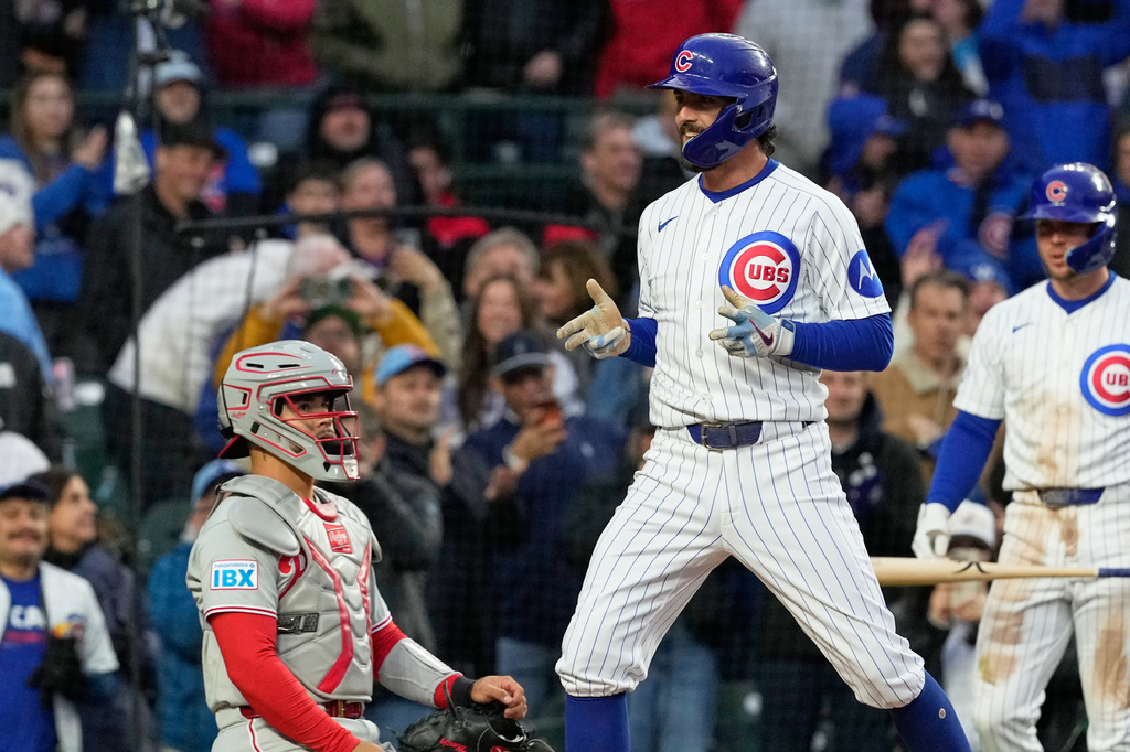 Chicago Cubs' Dansby Swanson, right, celebrates after hitting a three-run home run as Philadelphia Phillies catcher Rafael Marchán looks on during the second inning of a baseball game, in Chicago, Monday, April 20, 2026. (AP Photo/Nam Y. Huh)