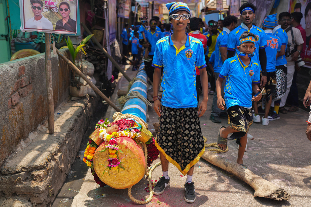 A boy poses for a photograph as members of the Agri-Koli community prepare to erect ceremonial bamboo poles in a centuries-old annual tradition honoring the local goddess Raiba Devi, in Rave village near Mumbai, India, Friday, April 17, 2026.(AP Photo/Rafiq Maqbool)