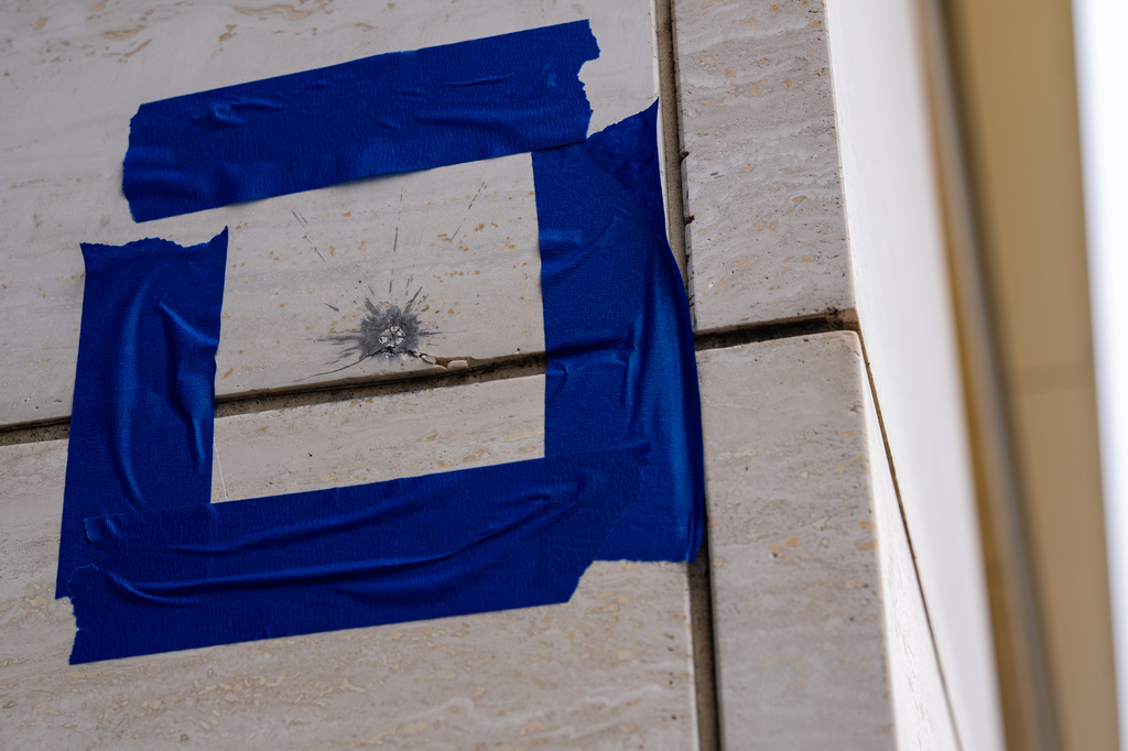 Blue tape is pictured around a possible bullet strike near the shooting scene near the scene of a shooting close to the White House, Sunday, May 24, 2026, in Washington. (AP Photo/Alex Brandon)