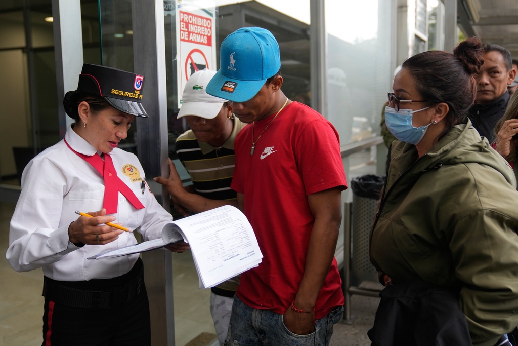 Yeferson de la Hoz, center, the cousin of soldier Mauro Penaranda who was on the cargo plane that crashed the previous day after take off in Puerto Leguizamo, arrives at the military hospital where he is being treated in Bogota, Colombia, Tuesday, March 24, 2026. (AP Photo/Fernando Vergara)
