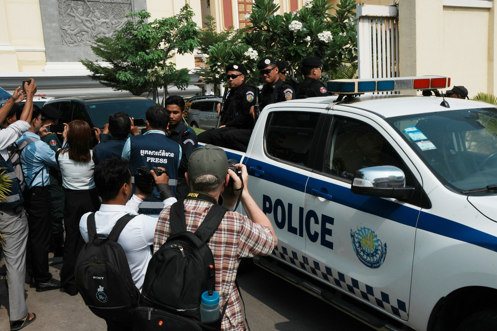 Journalists try to photograph as a vehicle which is believed to carry former Cambodia National Rescue Party's President Kem Sokha heads out from an appeals court after the court session in Phnom Penh, Cambodia, Thursday, April 30, 2026. (AP Photo/Heng Sinith)