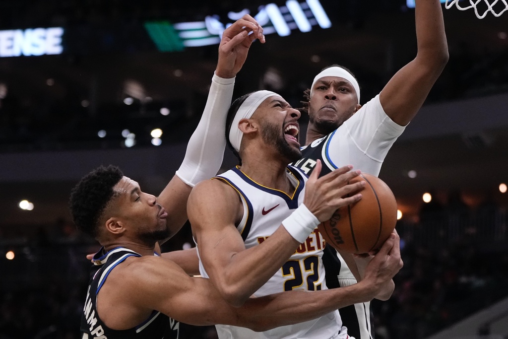 Denver Nuggets' Zeke Nnaji looks to shoot past Milwaukee Bucks' Giannis Antetokounmpo and Myles Turner during the first half of an NBA basketball game Friday, Jan. 23, 2026, in Milwaukee. (AP Photo/Morry Gash)