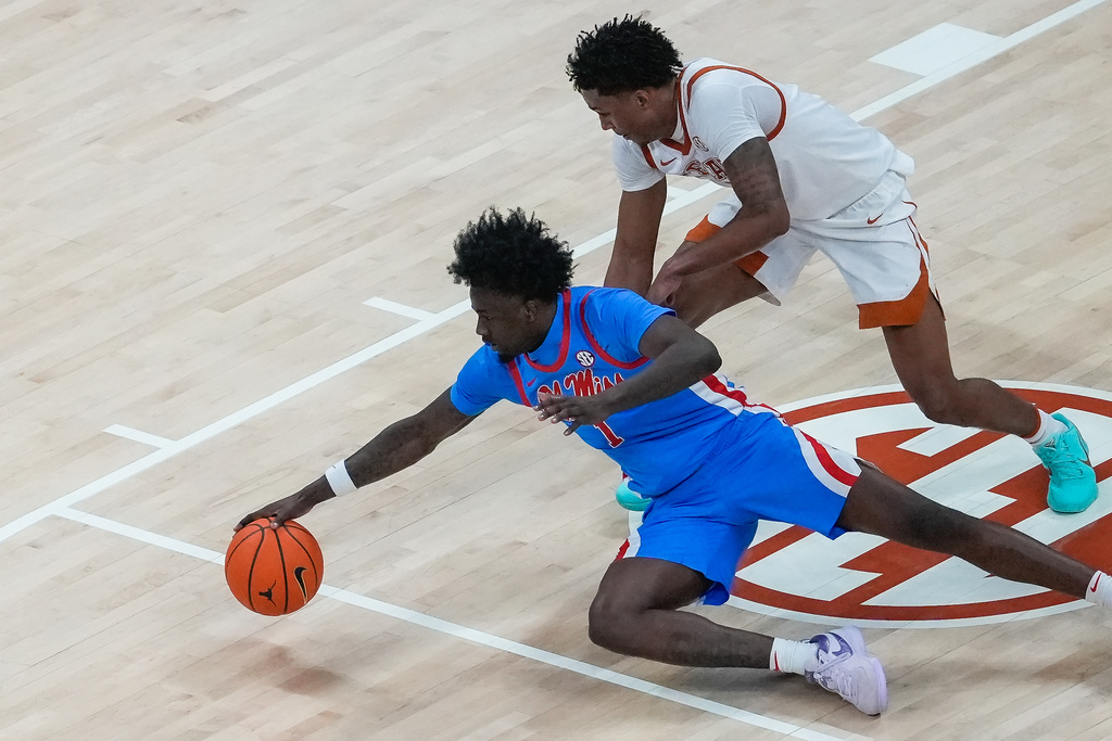 Texas forward Dailyn Swain (3) and Mississippi forward Corey Chest (1) dive after a loose ball during the first half of an during an NCAA college basketball game, Saturday, Feb. 7, 2026, in Austin, Texas. (Sara Diggins/Austin American-Statesman via AP)