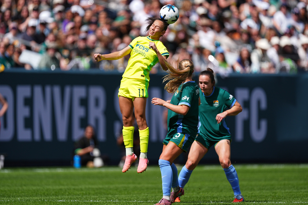 Washington Spirit forward Claudia Martinez, left, heads the ball as Denver Summit FC midfielder Devin Lynch, front right, and defender Megan Reid cover in the second half of an NWSL soccer match, Saturday, March 28, 2026, in Denver. (AP Photo/David Zalubowski)