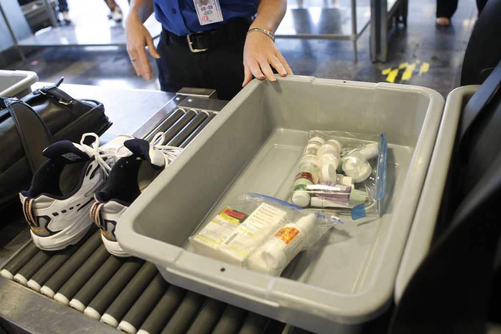 FILE - Shoes and small liquid containers are placed in bins to be screened by TSA Supervisor Jennifer Haslip at Washington's Ronald Reagan National Airport, June 27, 2008. (AP Photo/Pablo Martinez Monsivais, File)
