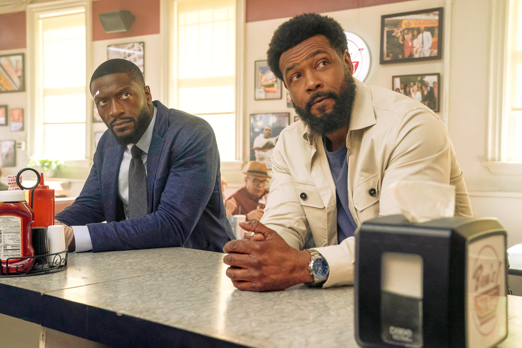 This image released by Prime Video shows Aldis Hodge as Alex Cross, left, and Isaiah Mustafa as John Sampson, in a scene from the series "Cross." (Ian Watson/Prime Video via AP)