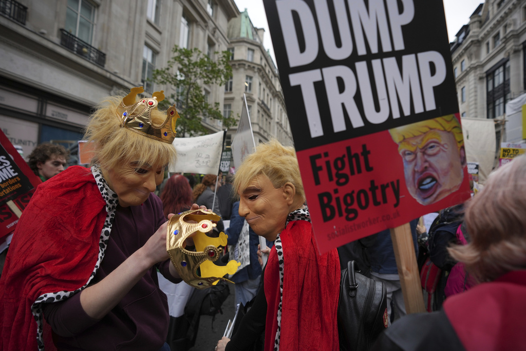 Protesters in costumes adjust their crowns during a demonstration of the Stop Trump Coalition group against President Donald Trump's state visit in London, Wednesday, Sept. 17, 2025.(AP Photo/Kin Cheung)