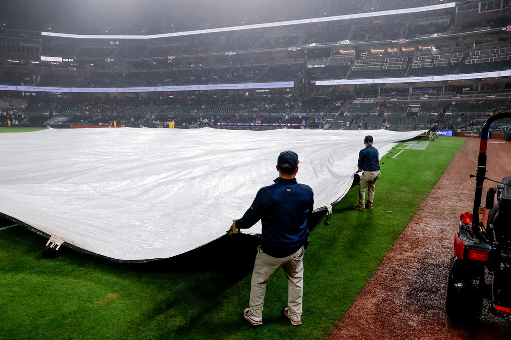 Atlanta Braves grounds crew cover the infield with a tarp after the game was suspended due to weather in the second inning of a baseball game, Tuesday, June 16, 2026, in Atlanta. (AP Photo/Erik S. Lesser)