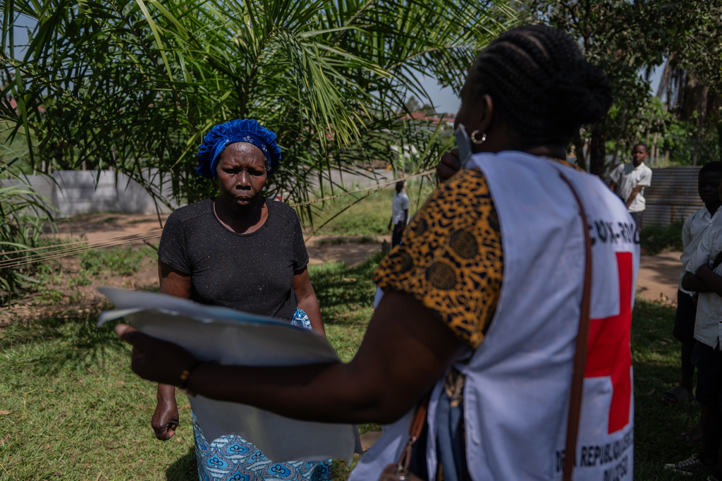 Vanny Birungi, a Red Cross volunteer, speaks to a woman during a house-to-house sensitisation campaign amid the Ebola outbreak in Bunia, Congo, Monday, May 25, 2026. (AP Photo/Moses Sawasawa)