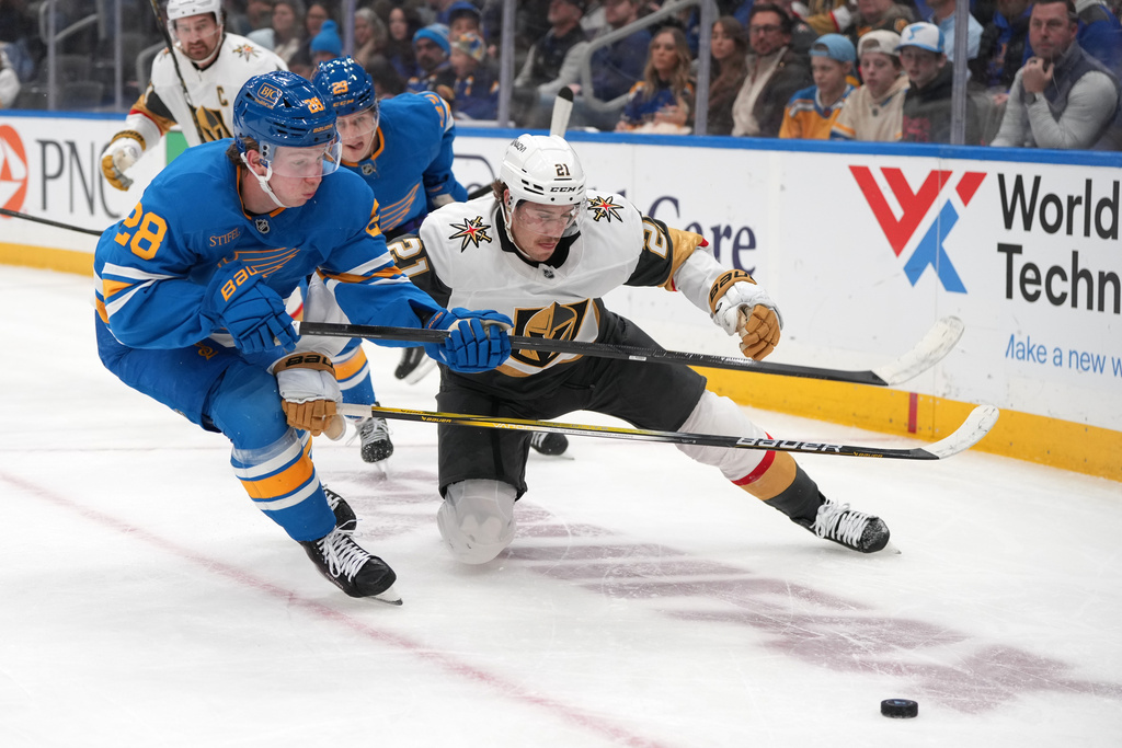 St. Louis Blues' Otto Stenberg (28) and Vegas Golden Knights' Brett Howden (21) chase after a loose puck along the boards during the first period of an NHL hockey game Friday, Jan. 2, 2026, in St. Louis. (AP Photo/Jeff Roberson)