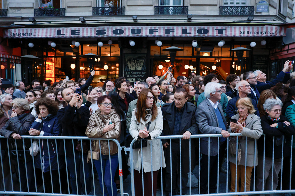 People stand along the route of the cenotaph of former French Justice Minister Robert Badinter, a revered rights defender who spearheaded France's drive to end the death penalty,during his induction ceremony into the Pantheon monument, Thursday, Oct. 9, 2025 in Paris. (Stephanie Lecocq/Pool photo via AP)
