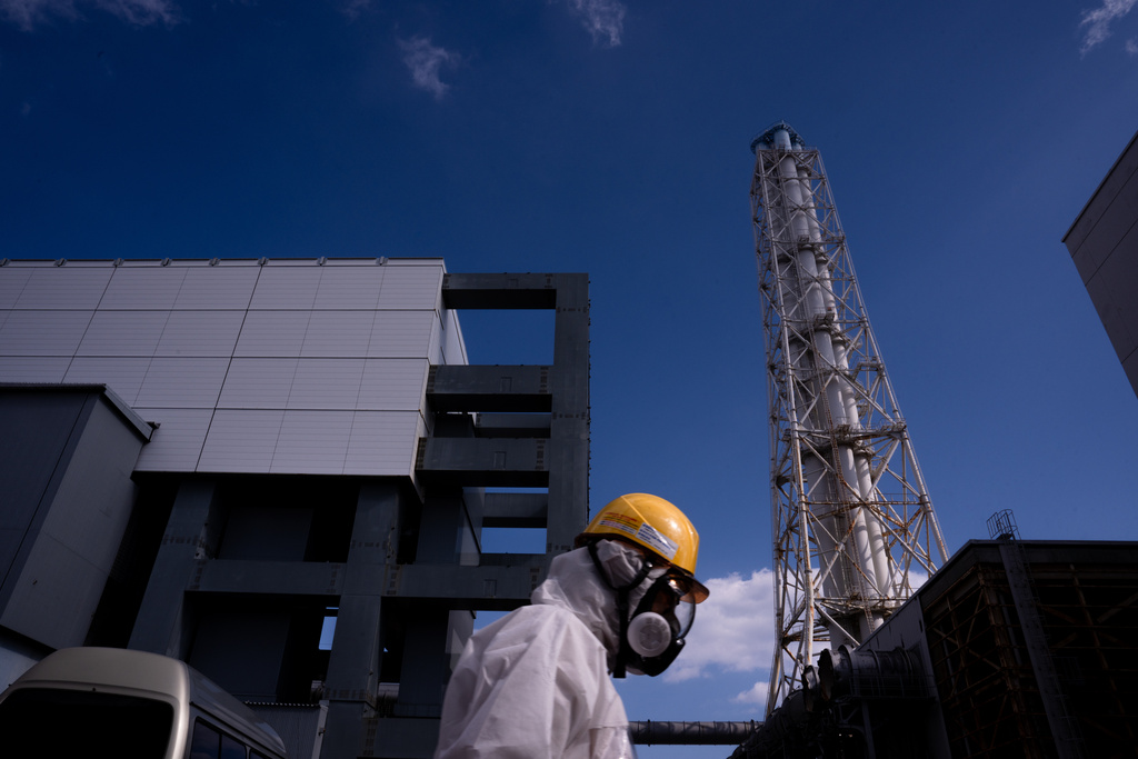 A worker walks past the Unit 4 reactor at the Fukushima Daiichi nuclear power plant, operated by Tokyo Electric Power Company (TEPCO), in Okuma, Fukushima Prefecture, Thursday, Feb. 12, 2026. (AP Photo/Louise Delmotte)