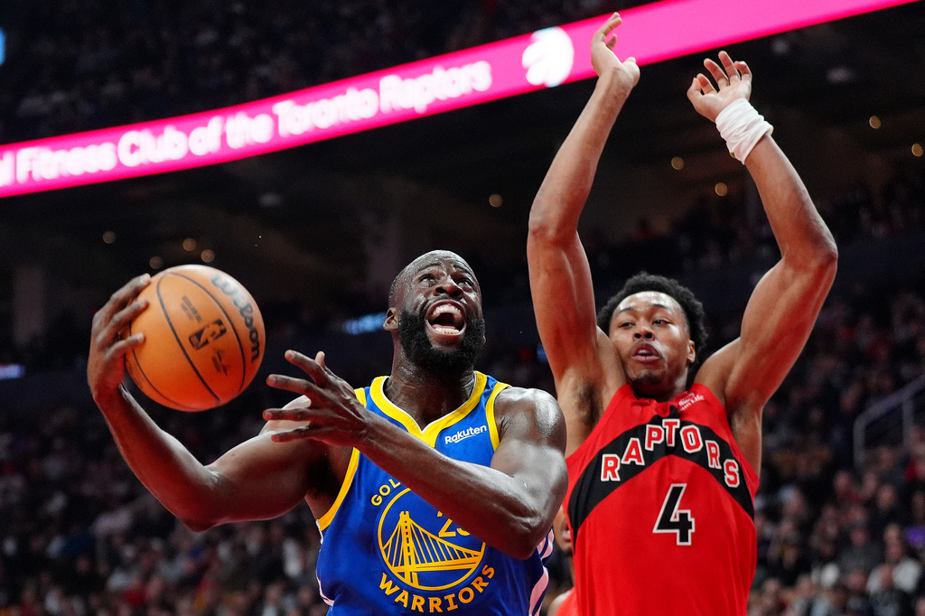 Golden State Warriors forward Draymond Green, left, drives to the net past Toronto Raptors forward Scottie Barnes (4) during first-half NBA basketball game action in Toronto, Sunday, Dec. 28, 2025. (Frank Gunn/The Canadian Press via AP)
