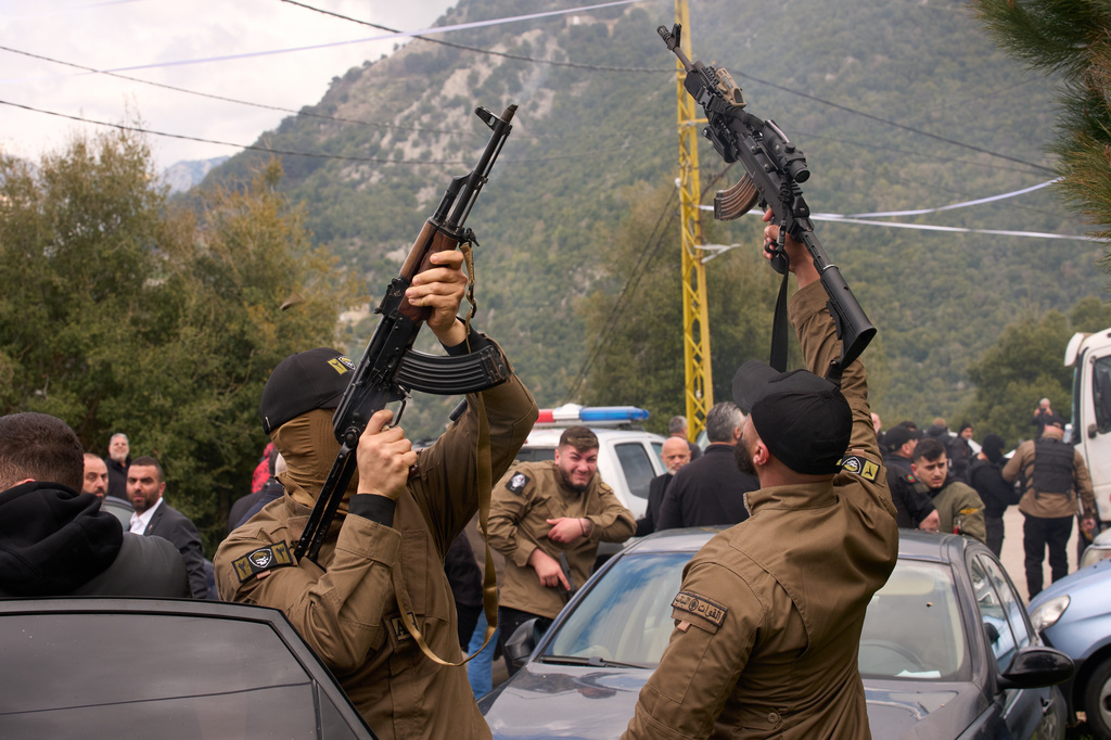 Gunmen fire their weapons as men carry the coffins with the bodies of Pierre Mouawad, an official with the anti-Hezbollah Lebanese Forces party, and his wife during their funeral in Yahshush, in Lebanon, Tuesday, April 7, 2026. (AP Photo/Emilio Morenatti)