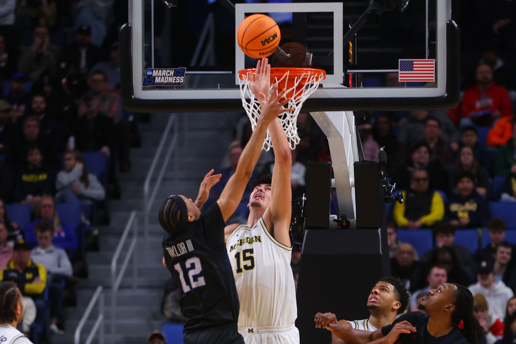 Michigan center Aday Mara (15) blocks a shot by Howard guard Cedric Taylor III (12) during the first half in the first round of the NCAA college basketball tournament, Thursday, March 19, 2026, in Buffalo, N.Y. (AP Photo/Jeffrey T. Barnes)