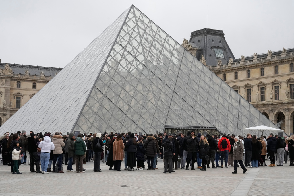 People queue outside the Louvre museum, in Paris, France, Friday, Feb. 13, 2026. (AP Photo/Michel Euler)