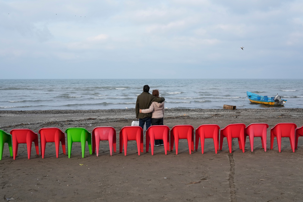 People enjoy their time at the beach of the southern coast of the Caspian Sea outside the port city of Bandar Anzali, Iran, Tuesday, Dec. 23, 2025. (AP Photo/Vahid Salemi)