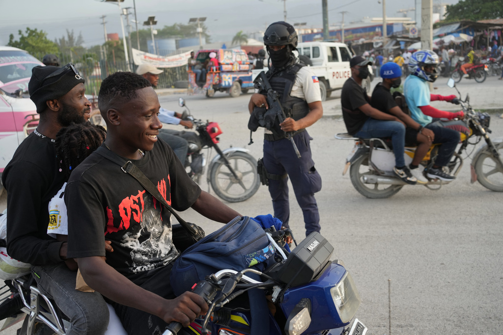 Police officers patrol an intersection in Port-au-Prince, Haiti, Tuesday, Sept. 30, 2025. (AP Photo/Odelyn Joseph)