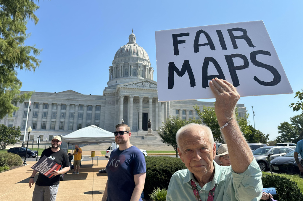 This photo taken with a smartphone shows Steve Perry, of Kansas City, holding a sign in opposition to Missouri’s congressional redistricting plan on Wednesday, Sept. 2, 2026, outside the state Capitol, in Jefferson City, Mo. (AP Photo/David A. Lieb)