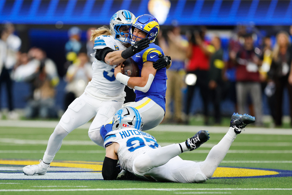 Los Angeles Rams quarterback Matthew Stafford is tackled by Detroit Lions middle linebacker Alex Anzalone, top left, and defensive end Aidan Hutchinson (97) during the first half of an NFL football game Sunday, Dec. 14, 2025, in Inglewood, Calif. (AP Photo/Caroline Brehman)