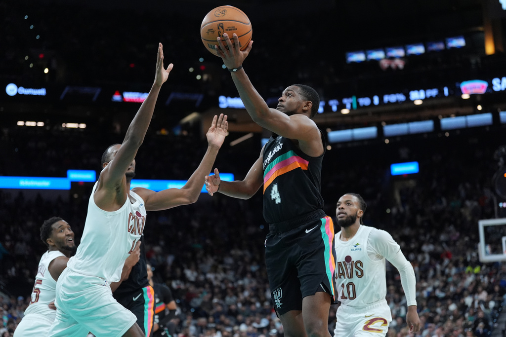 San Antonio Spurs guard De'Aaron Fox (4) drives to the basket abasing Cleveland Cavaliers center Evan Mobley (4) during the second half of an NBA basketball game in San Antonio, Monday, Dec. 29, 2025. (AP Photo/Eric Gay)