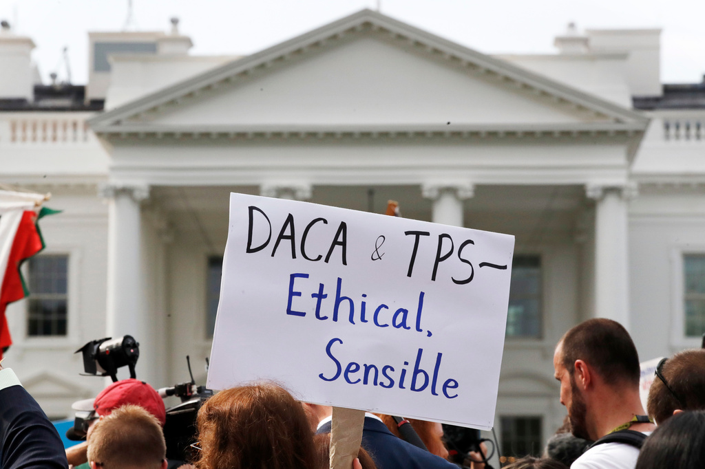 A person holds up a sign in support of the Deferred Action for Childhood Arrivals, known as DACA, and Temporary Protected Status programs during a rally in support of DACA and TPS outside of the White House, in Washington, Sept. 5, 2017. (AP Photo/Jacquelyn Martin, file)