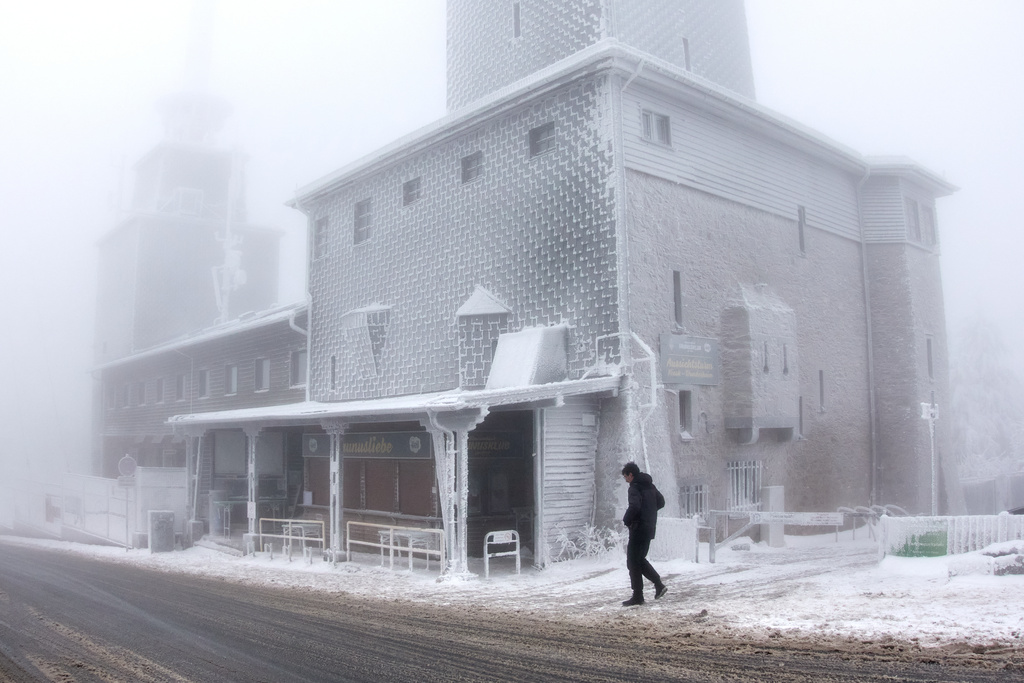 A man walks past an ice covered building on top of the Feldberg mountain near Frankfurt, Germany, Thursday, Jan. 8, 2026. (AP Photo/Michael Probst)