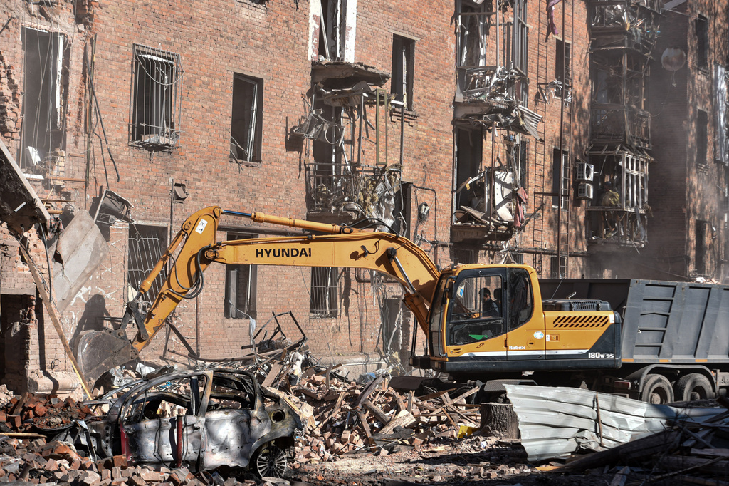 En excavator clears the rubble of a residential building destroyed by a Russian strike on Dnipro, Ukraine, Saturday, April 25, 2026. (AP Photo/Mykola Synelnykov)