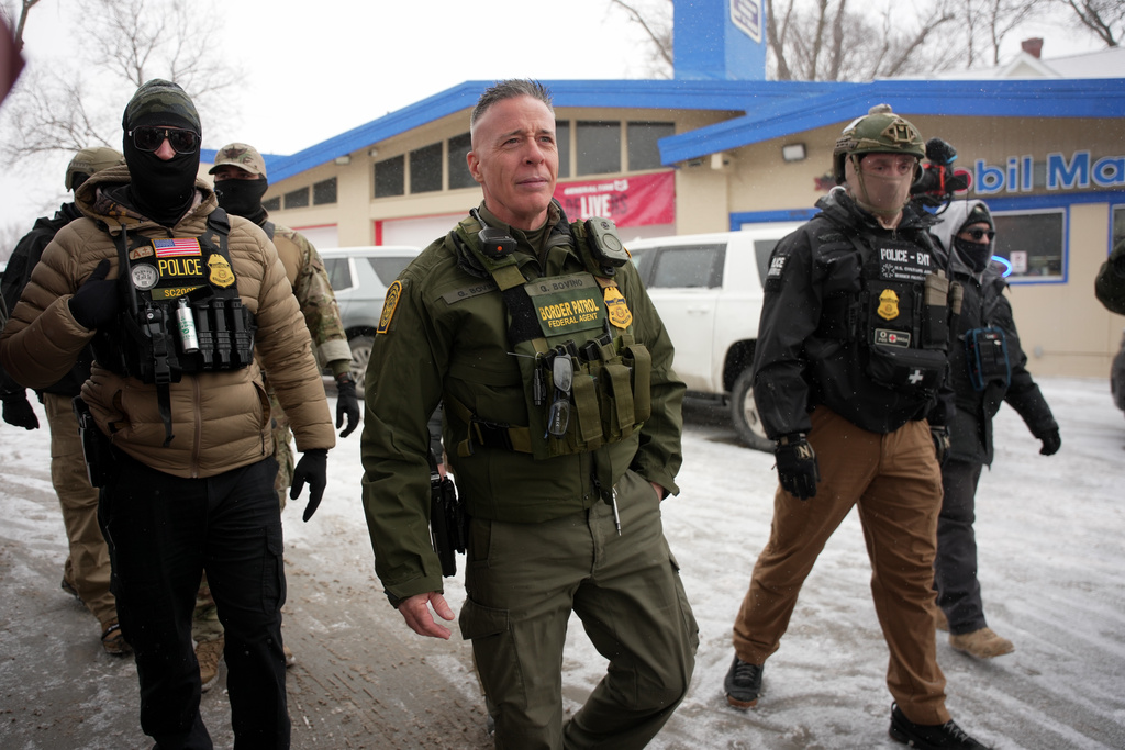 U.S. Border Patrol Cmdr. Gregory Bovino walks with Federal agents outside a convenience store on Wednesday, Jan. 21, 2026, in Minneapolis. (AP Photo/Angelina Katsanis)