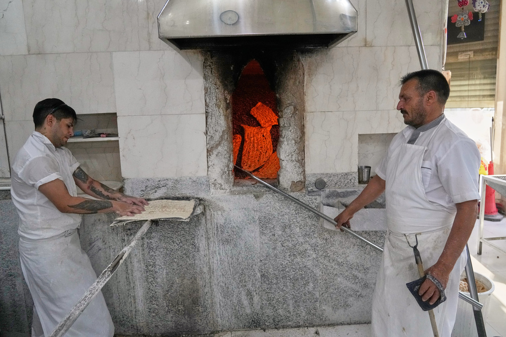 Workers prepare sangak, a traditional Iranian flatbread, at a bakery in Tehran, Iran, Tuesday, Aug. 18, 2026. (AP Photo/Vahid Salemi)