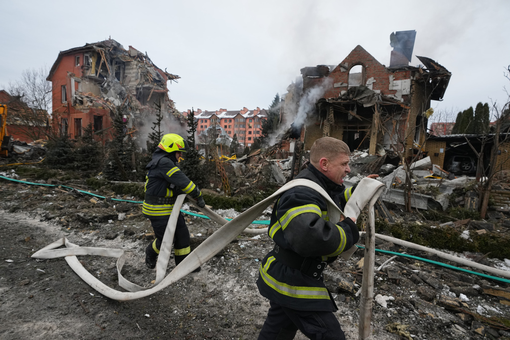 Firefighters put out a fire after a drone hit a residential building during a Russian air attack in Kyiv, Ukraine, Sunday, Feb. 22, 2026. (AP Photo/Sergei Grits)