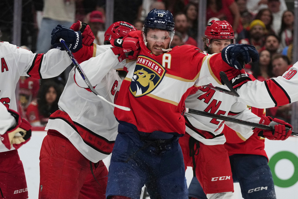 FILE - Florida Panthers left wing Matthew Tkachuk (19) scuffles with Carolina Hurricanes players during the second period in Game 3 of the NHL hockey Stanley Cup Eastern Conference finals Saturday, May 24, 2025, in Sunrise, Fla. (AP Photo/Lynne Sladky, File)