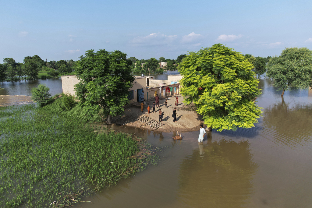 Villagers gather outside their homes, which are surrounding by floodwaters, in Tiba Gheal village, in Jhang district, Pakistan, Tuesday, Sept. 2, 2025. (AP Photo/Jahan Zeb)
